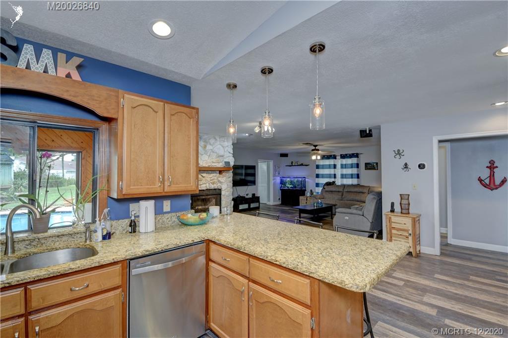 1654 Southwest 85th Terrace Stuart, FL 34997 - Photo 16 of 48 a kitchen with kitchen island a sink stove and cabinets