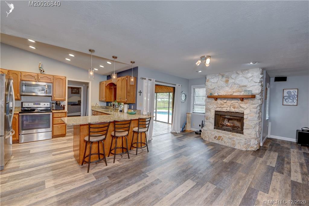 1654 Southwest 85th Terrace Stuart, FL 34997 - Photo 17 of 48 a dining hall with stainless steel appliances a stove top oven a sink and a fireplace