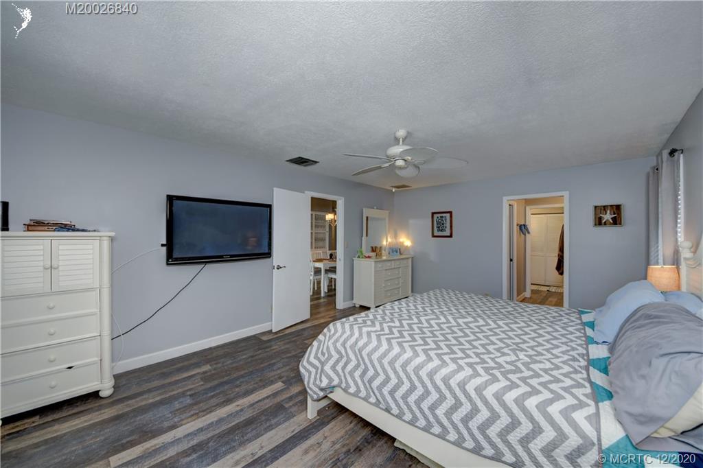 1654 Southwest 85th Terrace Stuart, FL 34997 - Photo 27 of 48 a bedroom with a bed and a flat screen tv