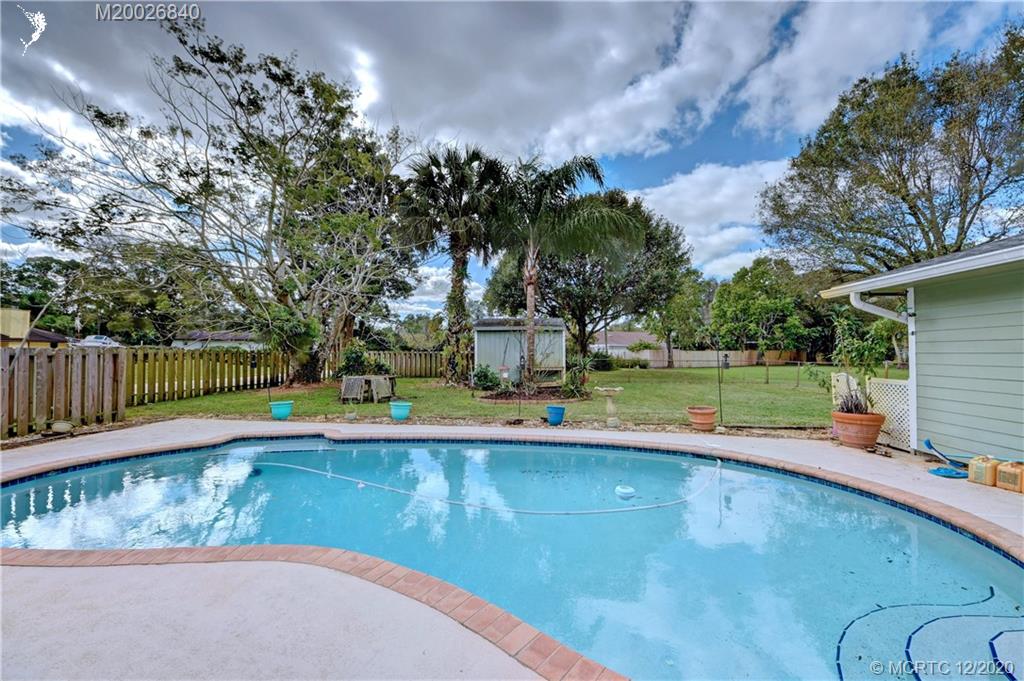 1654 Southwest 85th Terrace Stuart, FL 34997 - Photo 34 of 48 a view of a swimming pool with a patio and a yard