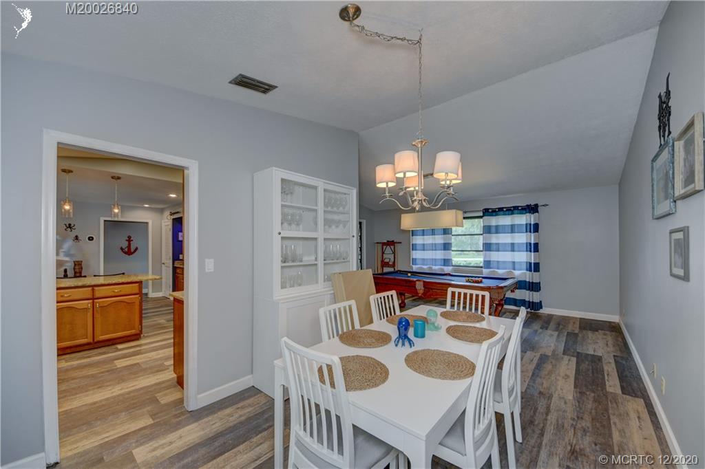 1654 Southwest 85th Terrace Stuart, FL 34997 - Photo 9 of 48 a view of a dining room with furniture a chandelier and wooden floor