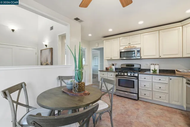 a kitchen with stainless steel appliances a stove a sink a microwave a refrigerator and cabinets