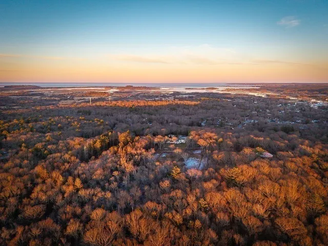 an aerial view of residential houses with city and green space