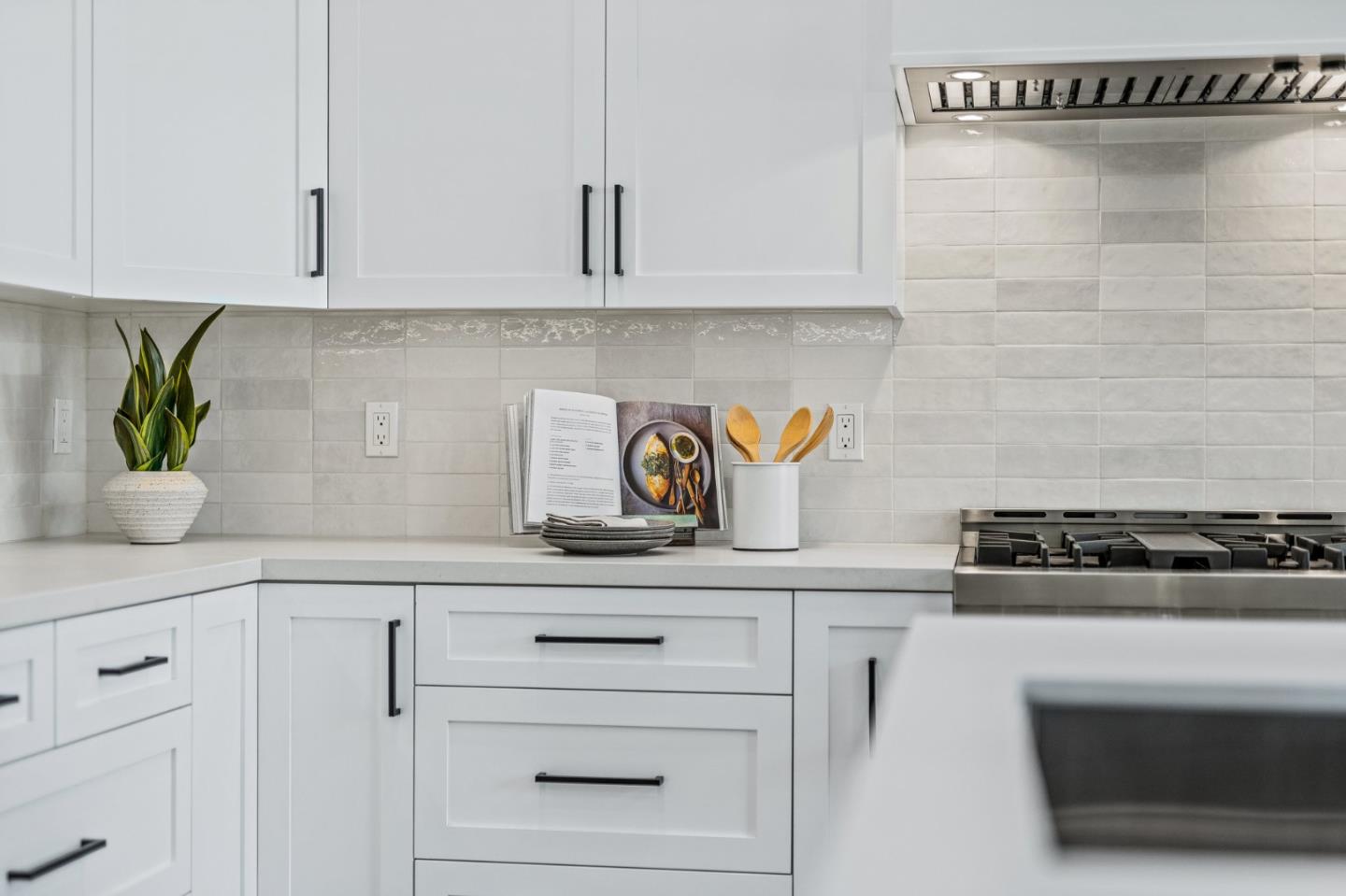 4875 Opal Street Capitola, CA 95010 - Photo 18 of 49 a kitchen with white cabinets and a stove