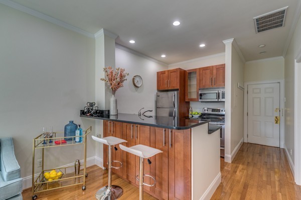 15 Garrison Street, Unit 9 Boston, MA 02116 - Photo 5 of 18 a kitchen with stainless steel appliances kitchen island granite countertop a refrigerator and a stove top oven