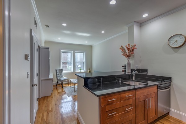 15 Garrison Street, Unit 9 Boston, MA 02116 - Photo 6 of 18 a kitchen with granite countertop a sink and a stove top oven
