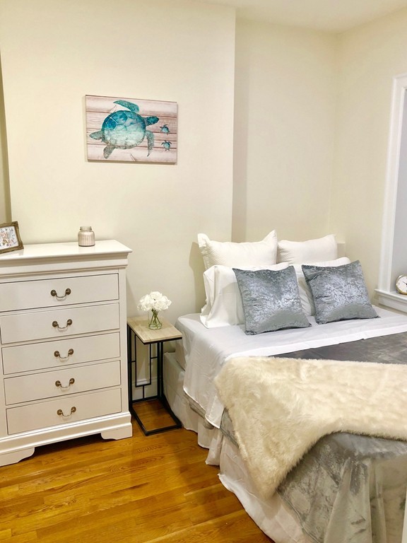 15 Garrison Street, Unit 9 Boston, MA 02116 - Photo 9 of 18 a bed room with a bed and a night stand