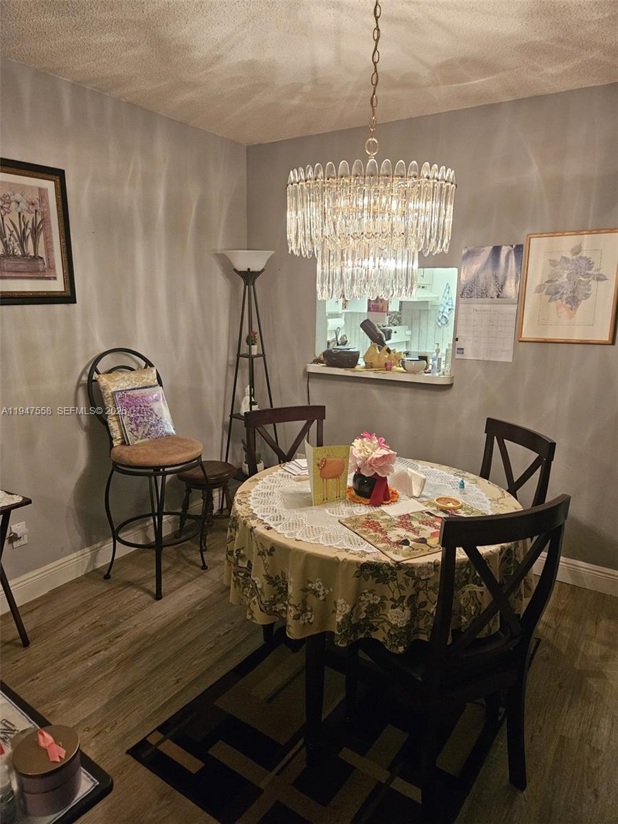 3591 Inverrary Drive, Unit 405 Lauderhill, FL 33319 - Photo 3 of 9 a dining room with furniture a chandelier and wooden floor