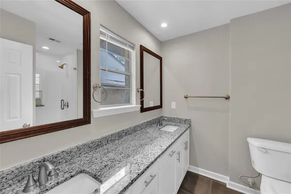 a bathroom with a granite countertop sink and a mirror