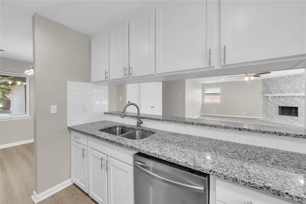 a kitchen with granite countertop a sink and cabinets