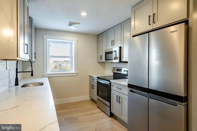 a kitchen with stainless steel appliances a refrigerator sink and microwave