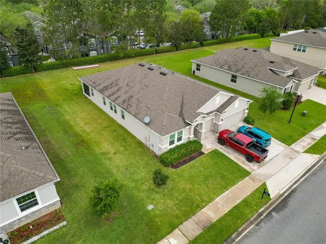 a view of a big house with a big yard and large trees