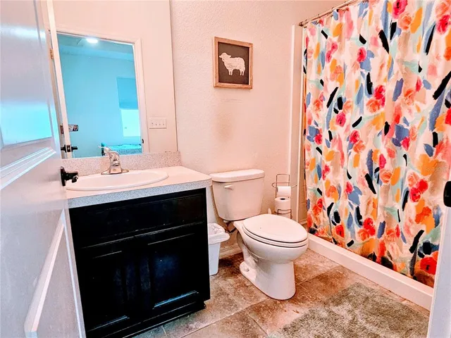 a bathroom with a toilet a sink and mirror