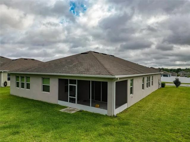 a view of house with yard and sitting area