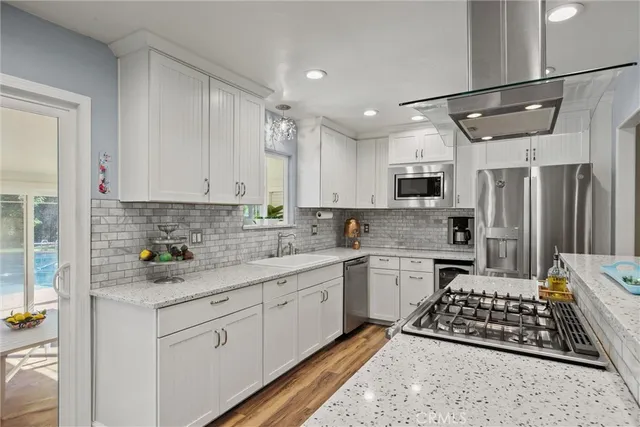 a kitchen with stainless steel appliances a sink stove and refrigerator
