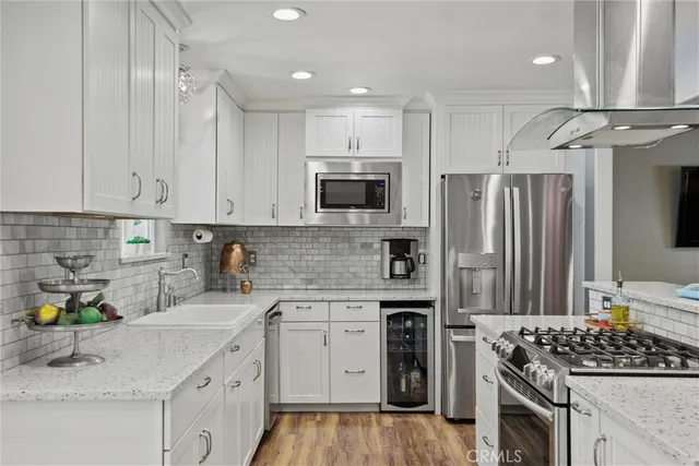 a kitchen with stainless steel appliances granite countertop a stove sink and cabinets