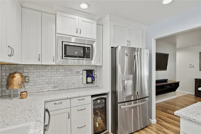 a kitchen with stainless steel appliances granite countertop a refrigerator and a sink