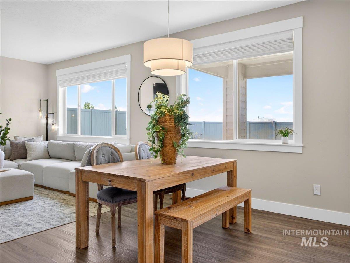 1811 Rome Avenue Emmett, ID 83617 - Photo 13 of 50 Open-concept living space featuring wood-finish flooring, a contemporary drum pendant light, and a dining area with a natural wood table