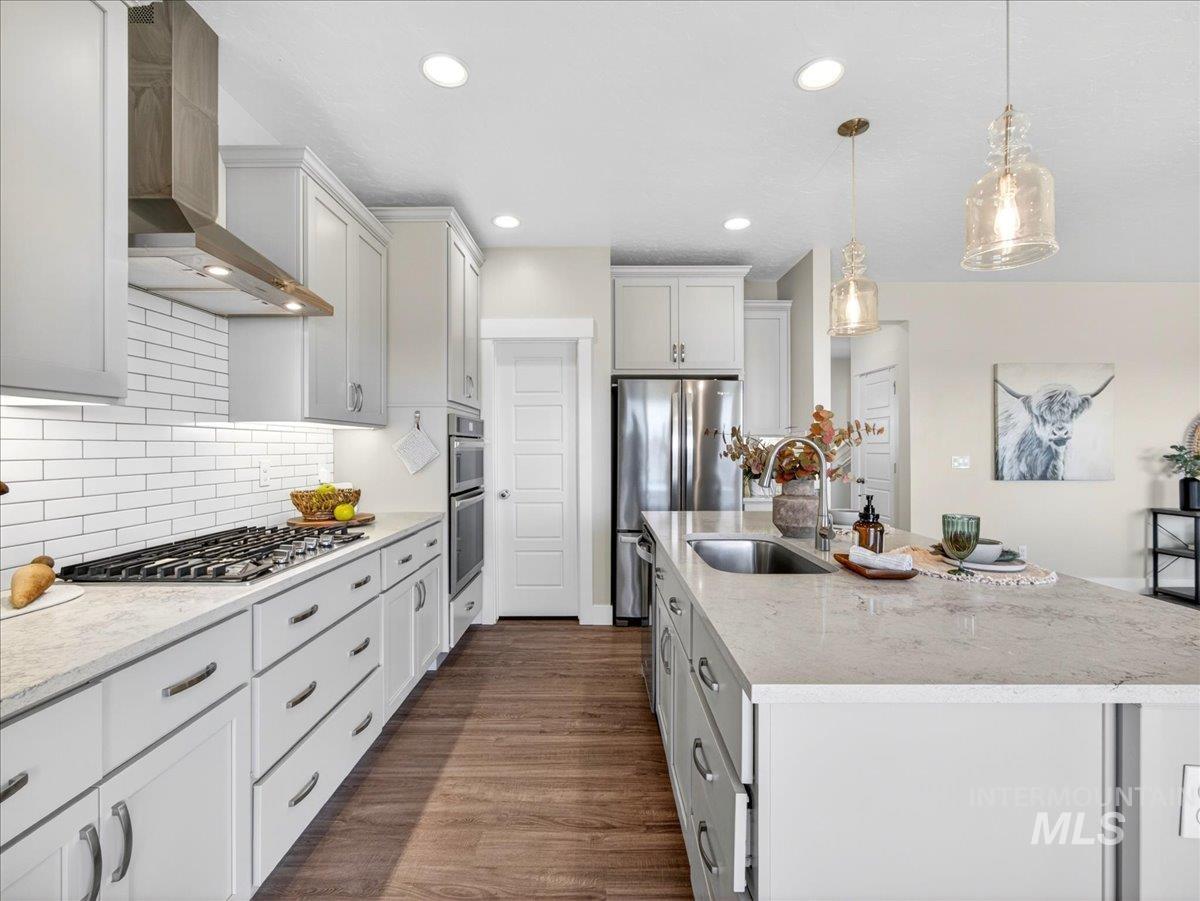 1811 Rome Avenue Emmett, ID 83617 - Photo 17 of 50 Modern kitchen featuring white cabinetry, light countertops, wood-finish flooring, stainless steel appliances, and a gas range