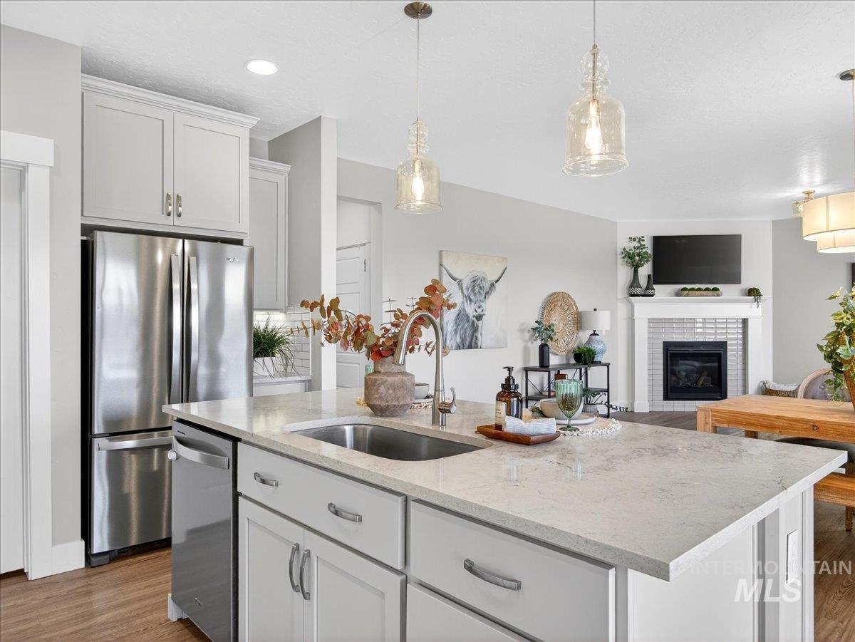 1811 Rome Avenue Emmett, ID 83617 - Photo 18 of 50 Kitchen island featuring an undermount sink, gooseneck faucet, and light-toned countertop