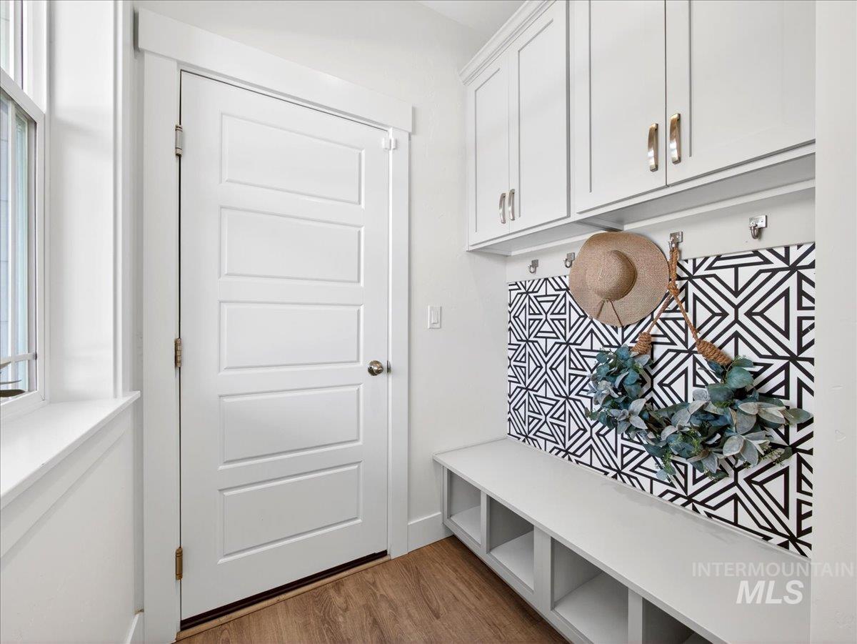 1811 Rome Avenue Emmett, ID 83617 - Photo 21 of 50 Mudroom featuring built-in cabinetry, integrated bench seating with open storage, wall hooks, and a geometric accent wall
