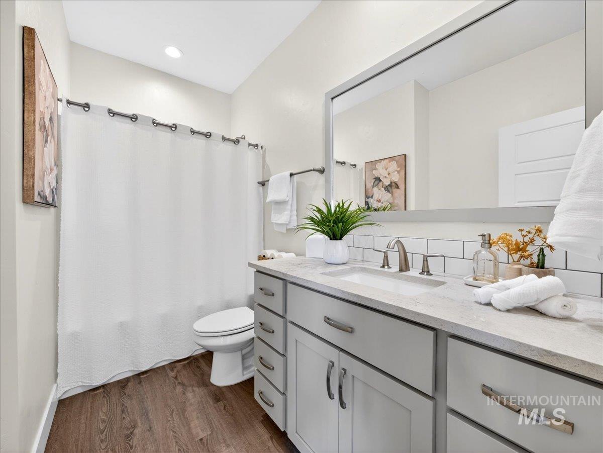 1811 Rome Avenue Emmett, ID 83617 - Photo 25 of 50 Bathroom featuring a light gray vanity with a built-in sink, brushed nickel faucet, subway tile backsplash, and coordinating framed mirror
