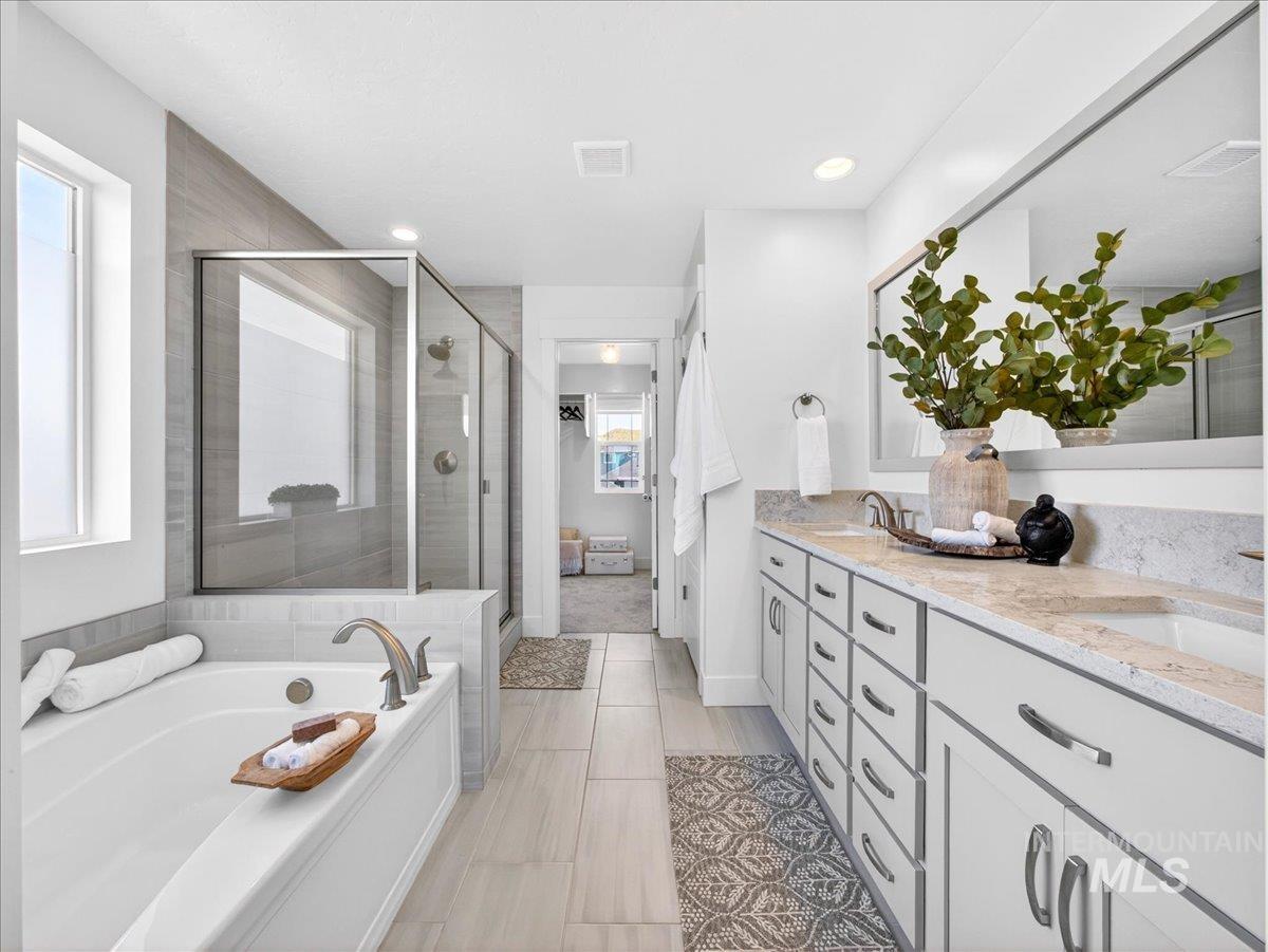 1811 Rome Avenue Emmett, ID 83617 - Photo 30 of 50 Contemporary bathroom featuring a large soaking tub, walk-in shower with glass enclosure, dual vanity with undermount sinks, stone countertops, and light wood-finish flooring