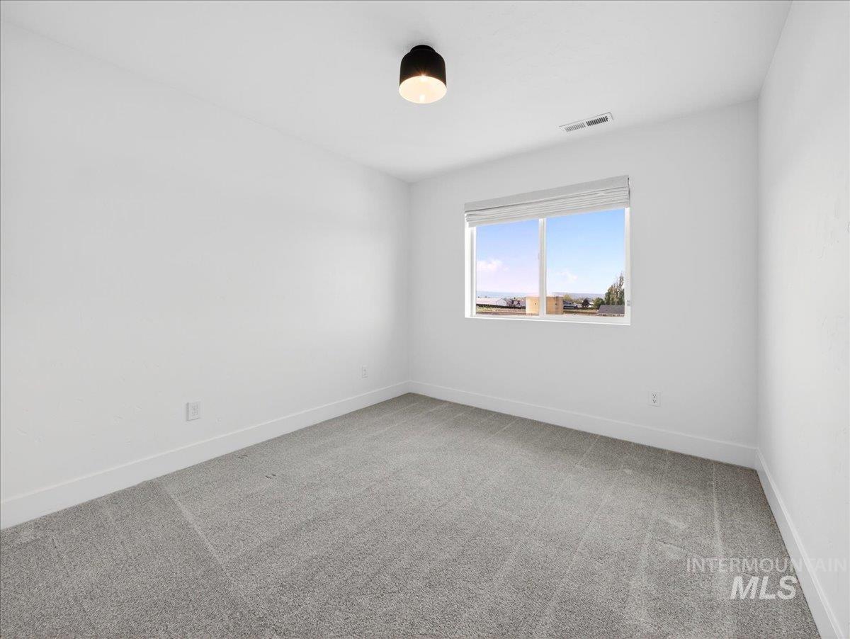 1811 Rome Avenue Emmett, ID 83617 - Photo 37 of 50 Bedroom featuring light gray carpet, white walls, and a large window with white blinds