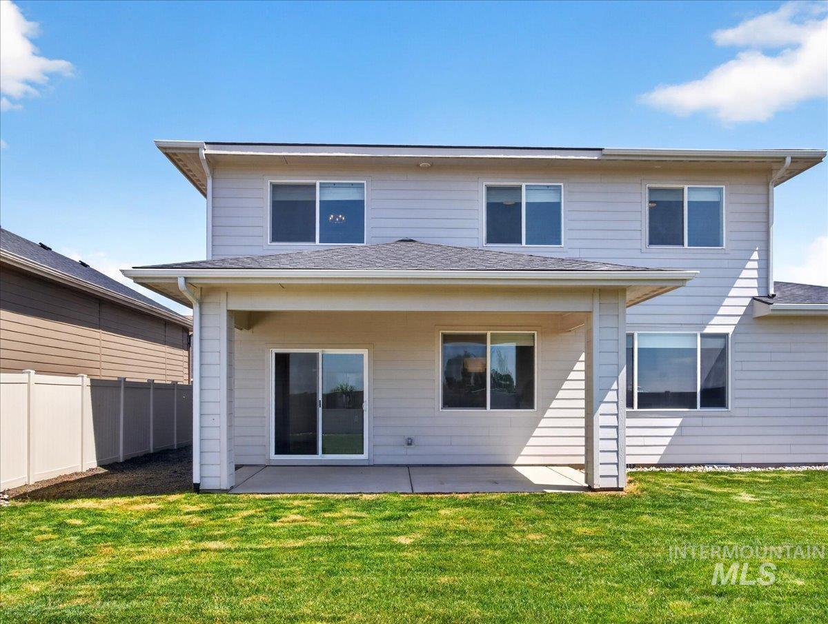1811 Rome Avenue Emmett, ID 83617 - Photo 41 of 50 Rear exterior featuring a covered patio, concrete slab, sliding glass door access, multiple windows, and a vinyl privacy fence