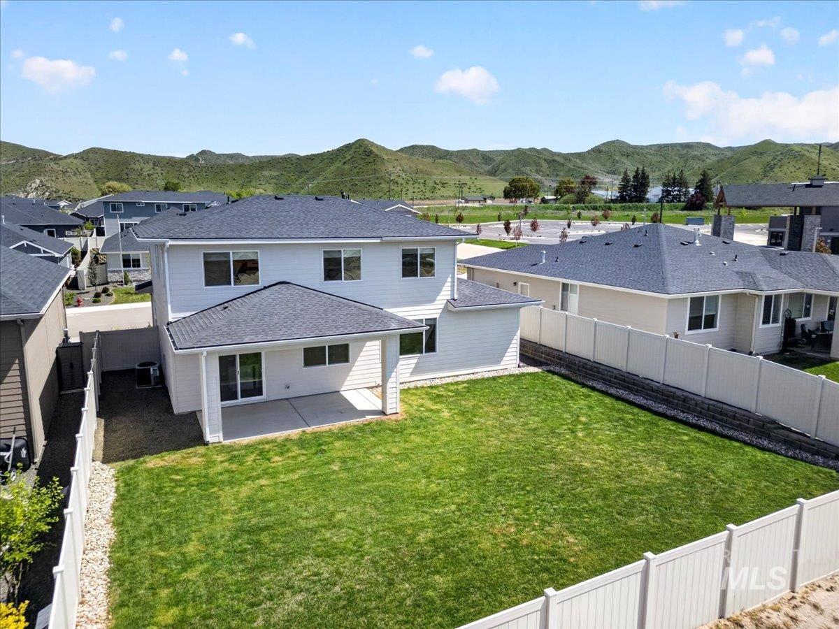 1811 Rome Avenue Emmett, ID 83617 - Photo 46 of 50 Rear exterior featuring a covered patio, expansive lawn, and a light-colored privacy fence