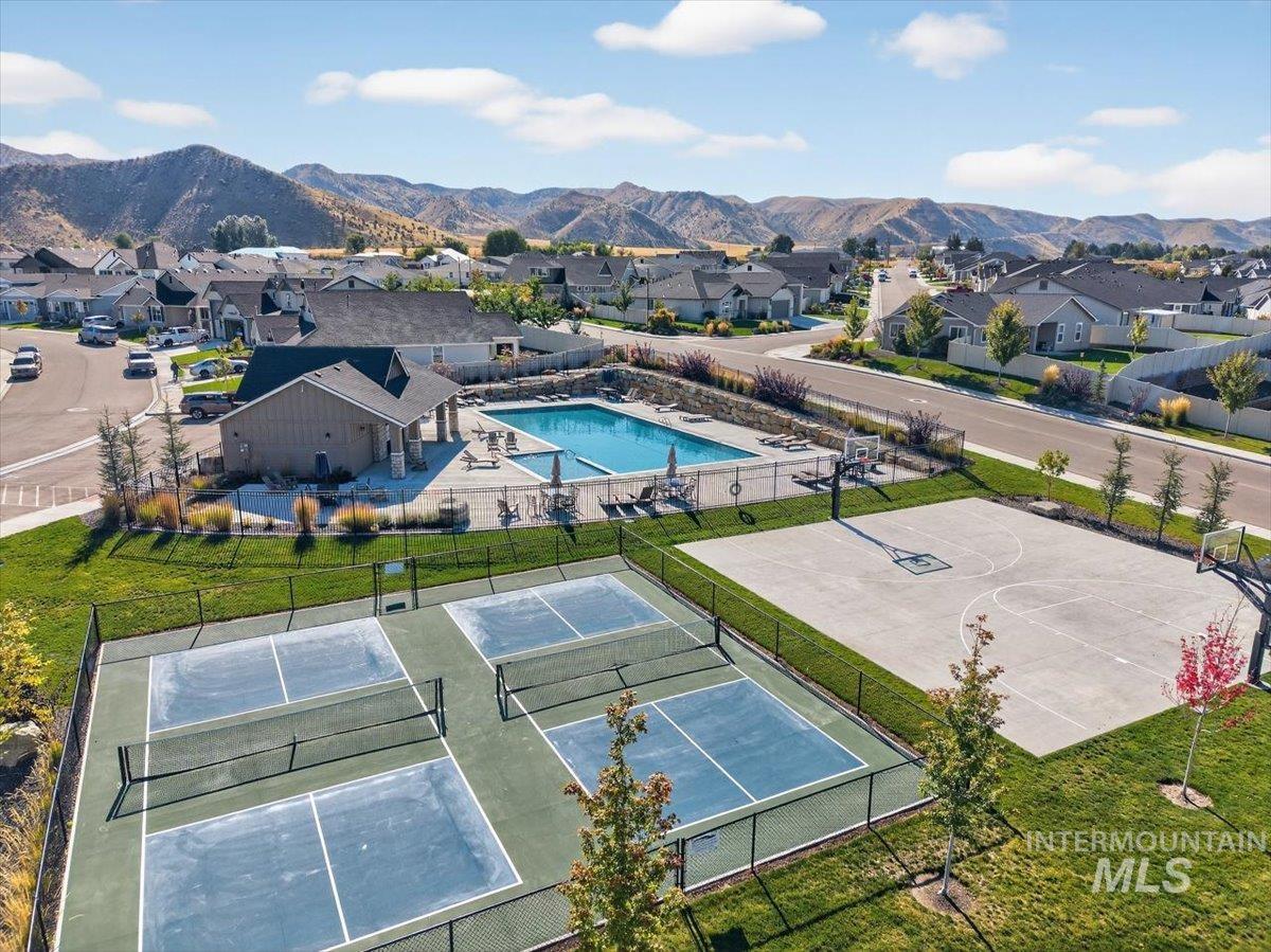 1811 Rome Avenue Emmett, ID 83617 - Photo 49 of 50 Community recreation area featuring a swimming pool, shaded lounge space, multiple pickleball courts, and a full basketball court, all surrounded by manicured lawns and mountain scenery