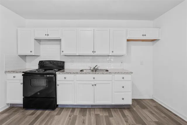 a kitchen with granite countertop white cabinets and stainless steel appliances
