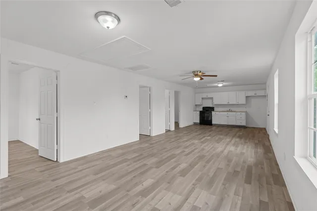 wooden floor in an empty room with a kitchen