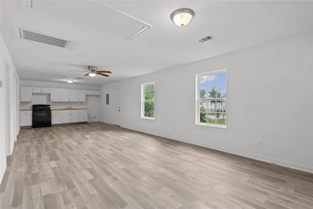 an empty room with windows and cabinet