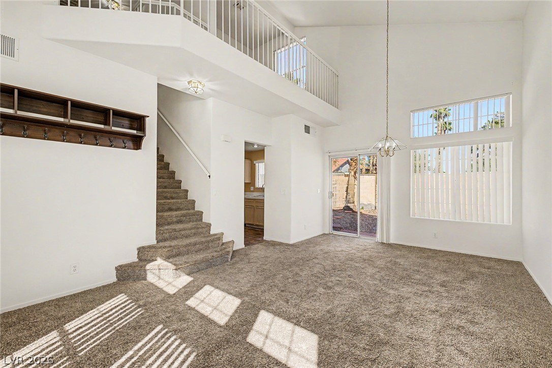 2223 Ramsgate Drive Henderson, NV 89074 - Photo 5 of 32 A grand, naturally illuminated living room awaits, boasting a two-story ceiling and direct outdoor access.