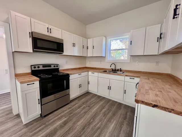 a kitchen with granite countertop white cabinets and white appliances