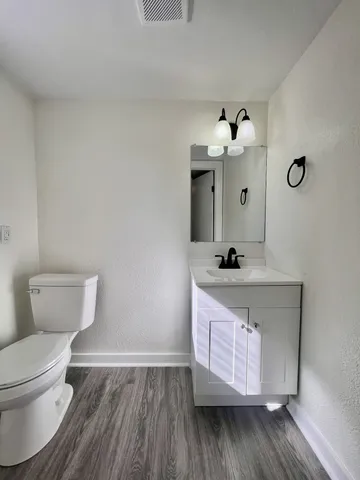 a bathroom with a sink mirror and toilet