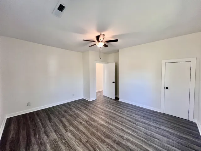 a view of an empty room with wooden floor