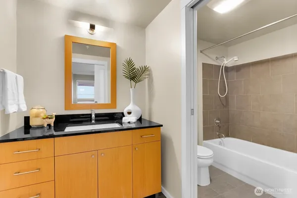 a bathroom with a granite countertop sink toilet and shower