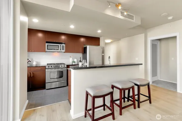 a kitchen with stainless steel appliances kitchen island granite countertop a sink and cabinets