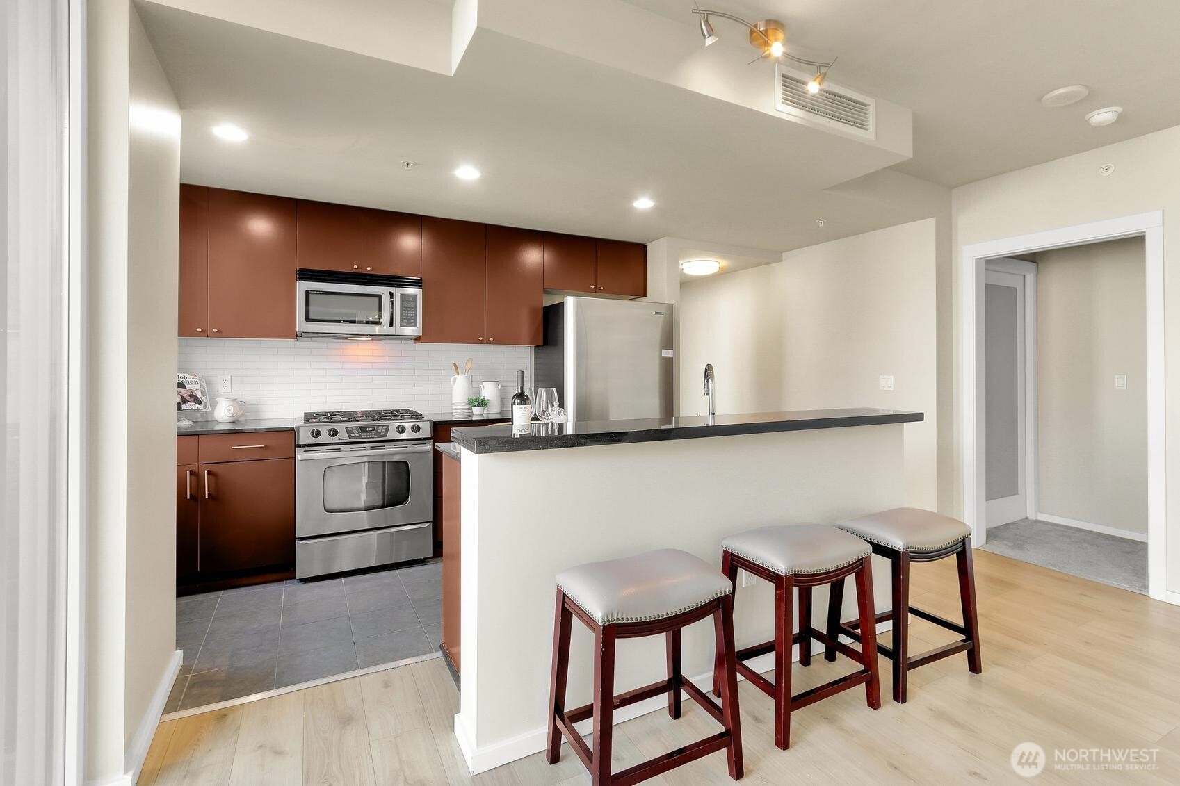 76 Cedar Street, Unit 808 Seattle, WA 98121 - Photo 8 of 20 a kitchen with stainless steel appliances kitchen island granite countertop a sink and cabinets