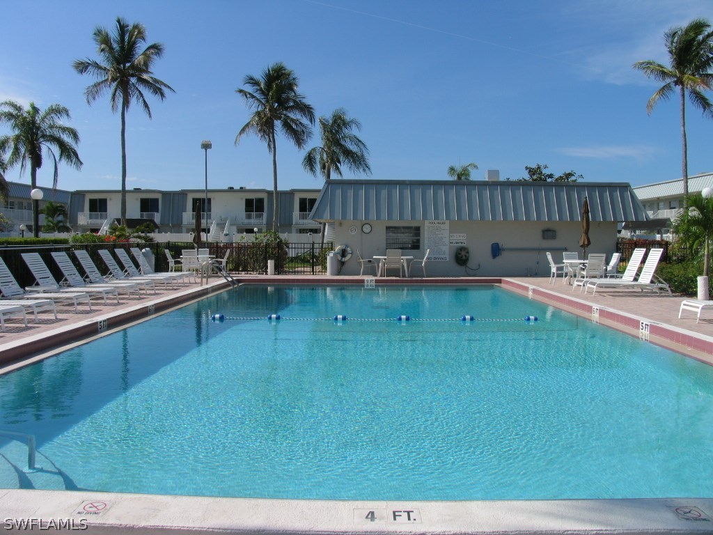 6777 Winkler Road, Unit D149 Fort Myers, FL 33919 - Photo 2 of 24 a view of a swimming pool with a table and chairs