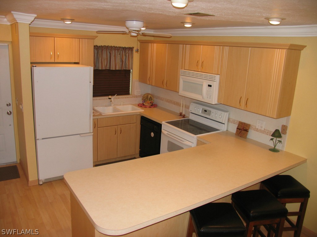 6777 Winkler Road, Unit D149 Fort Myers, FL 33919 - Photo 4 of 24 a kitchen with a sink a stove and refrigerator