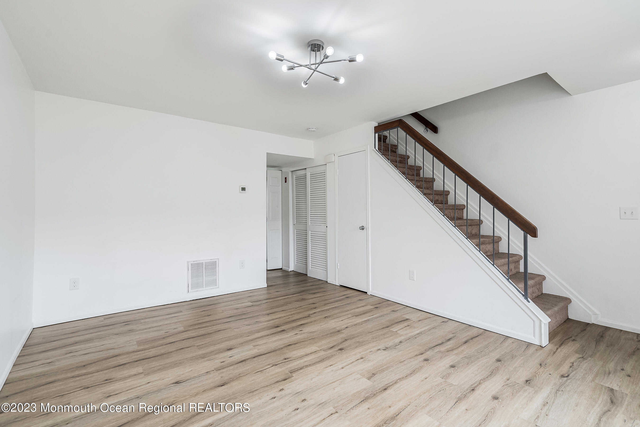 1054 Sawmill Road Brick, NJ 08724 - Photo 5 of 18 a view of an empty room with wooden floor and a ceiling fan