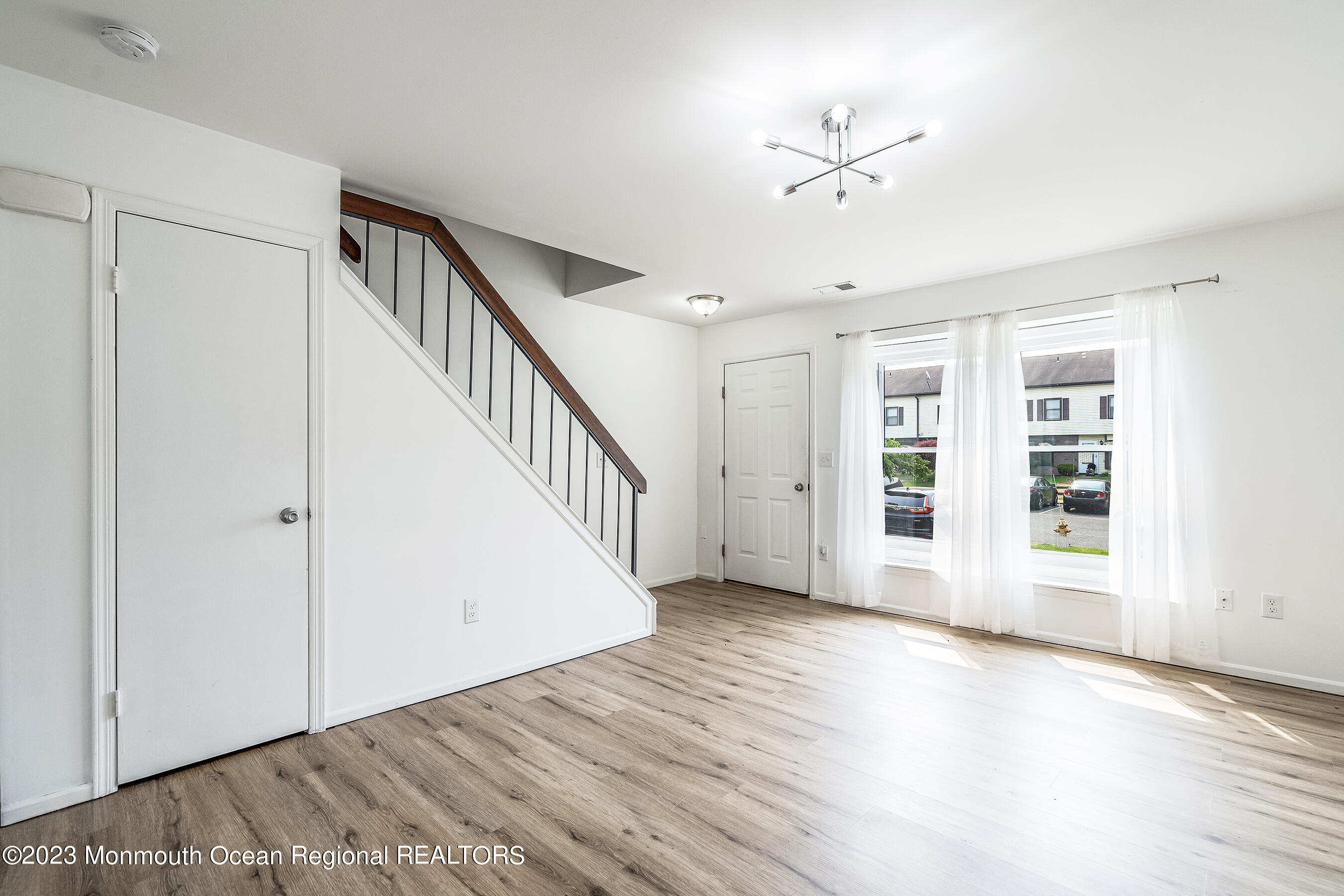 1054 Sawmill Road Brick, NJ 08724 - Photo 6 of 18 a view of an empty room with a window and wooden floor