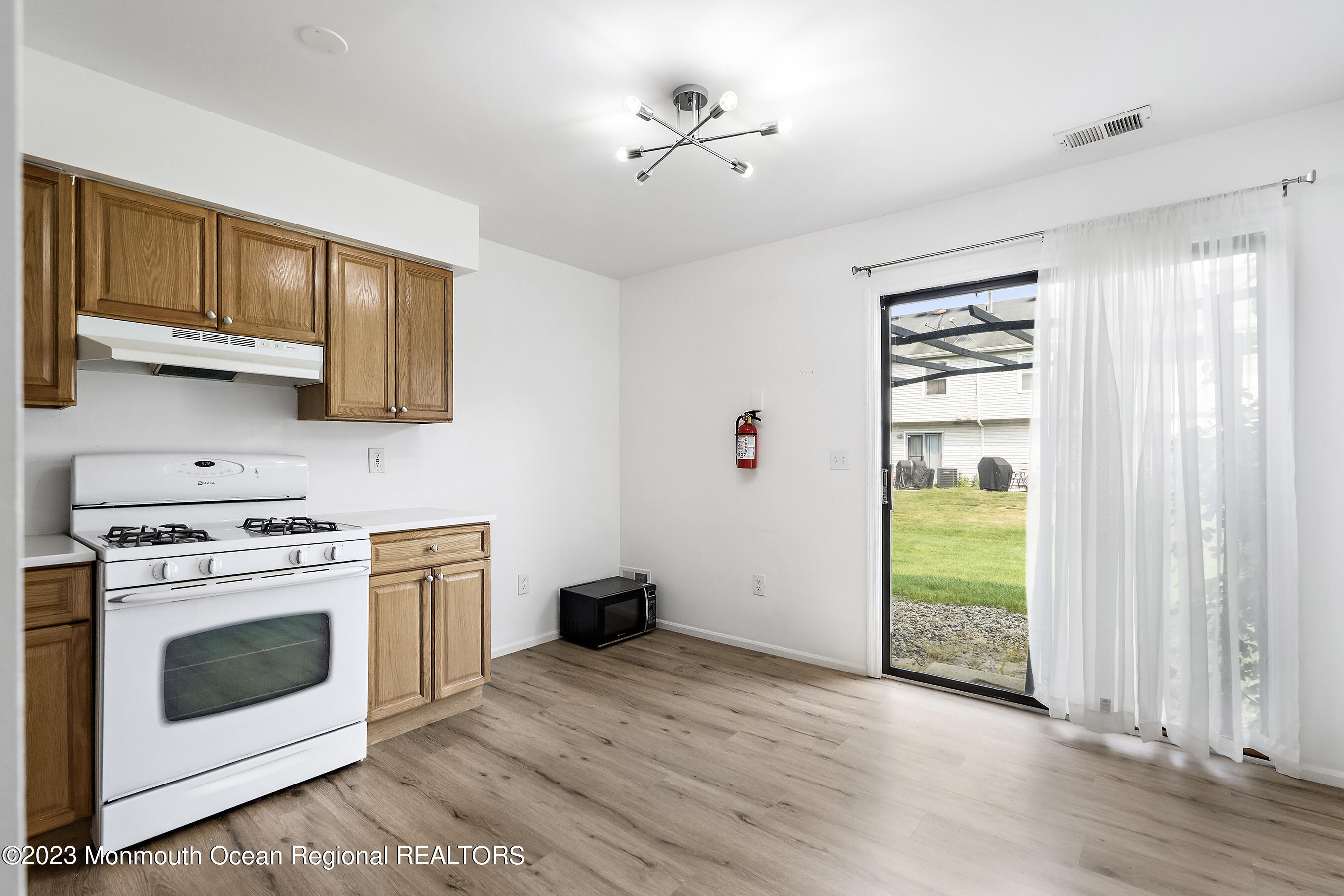 1054 Sawmill Road Brick, NJ 08724 - Photo 7 of 18 a kitchen with a stove a sink and a microwave