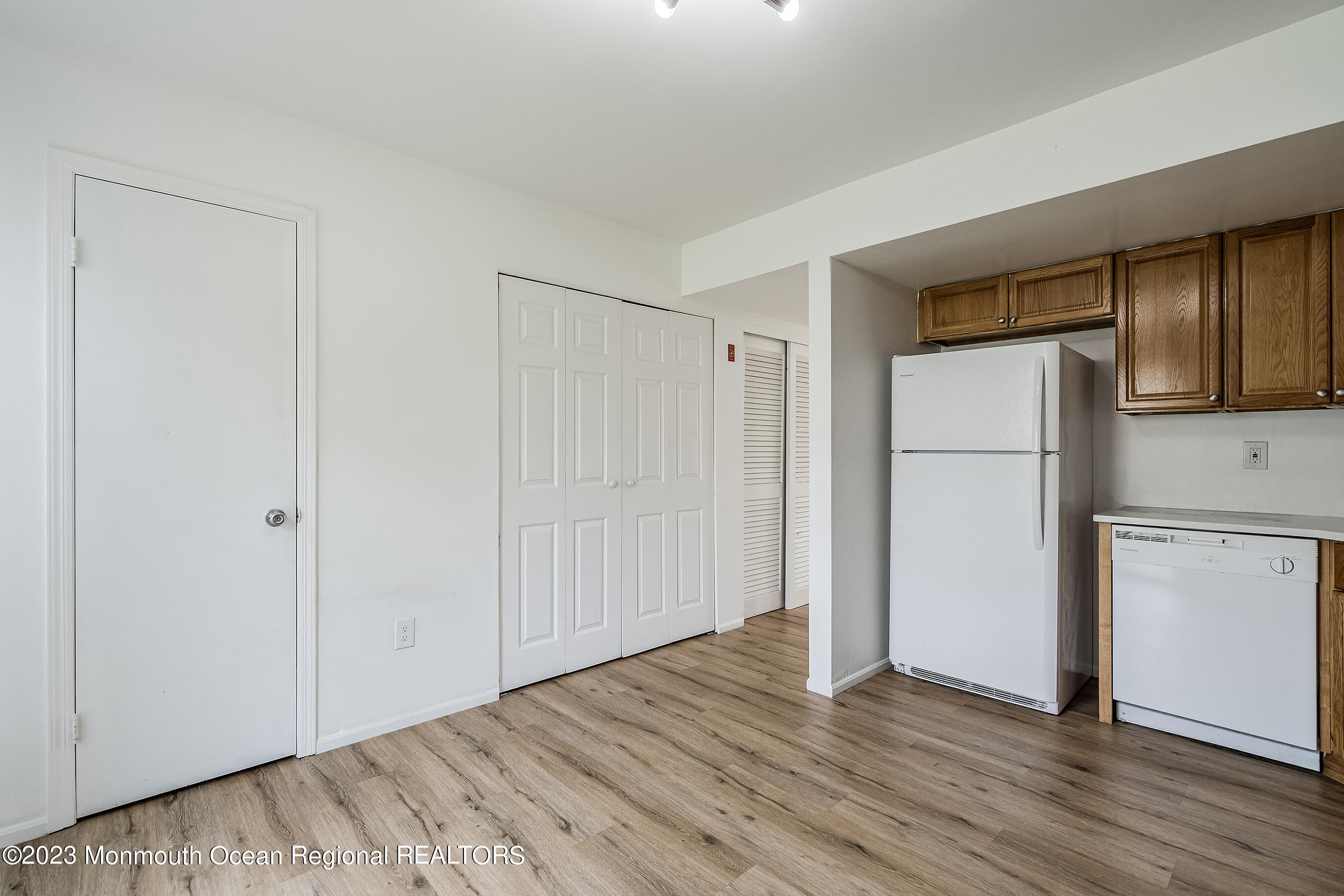 1054 Sawmill Road Brick, NJ 08724 - Photo 8 of 18 a view of an empty room with wooden floor and a kitchen
