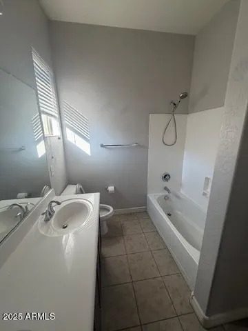 a bathroom with a granite countertop sink a mirror and bathtub