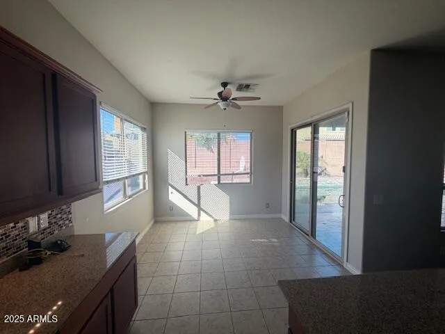 a kitchen with granite countertop a stove a sink and a refrigerator