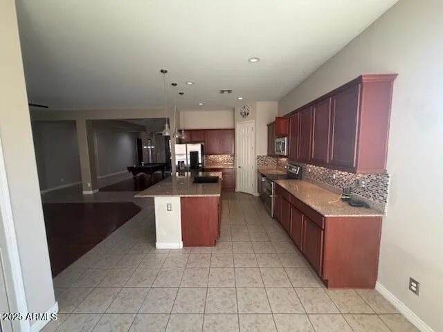 a large kitchen with stainless steel appliances kitchen island granite countertop a large counter top and a stove